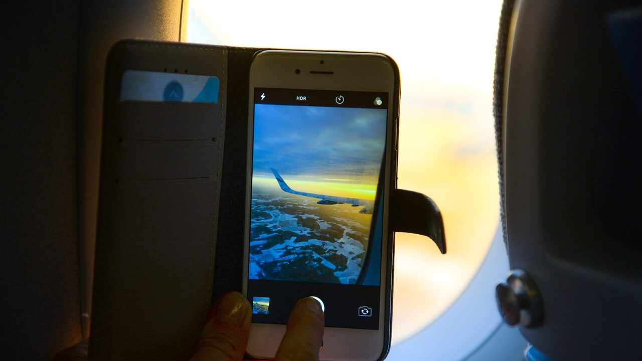 Person wearing headphones on airplane window seat