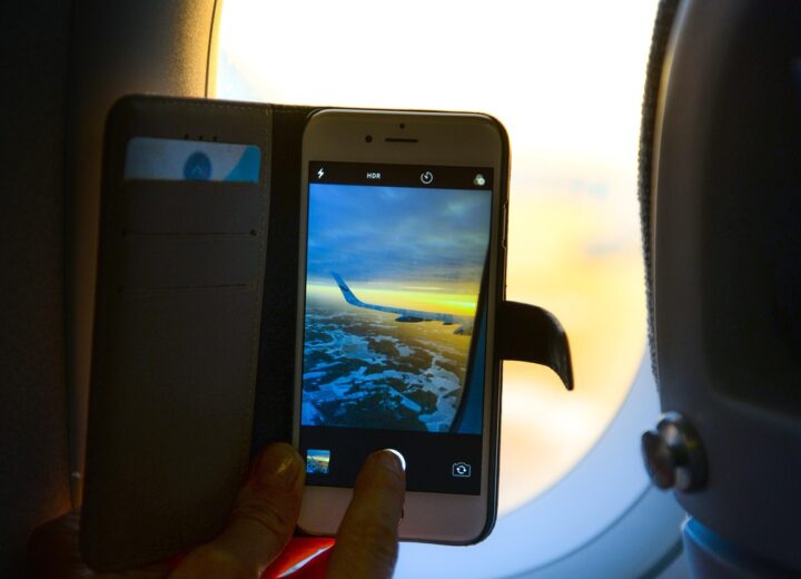 Person wearing headphones on airplane window seat